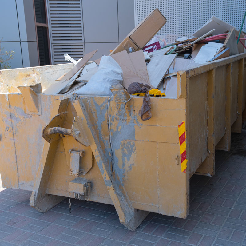 pile of trash in a yellow dumpster